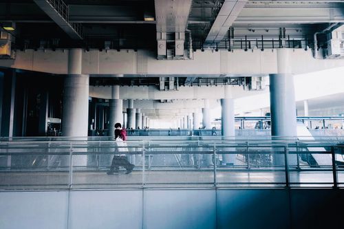 Free A contemporary urban scene featuring a pedestrian walkway beneath a modern overpass. Stock Photo