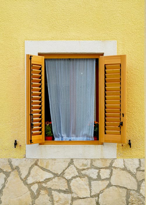 Sheer Curtain in Window with Open Wooden Window Shutters