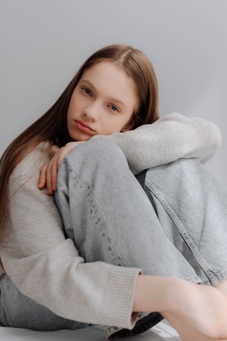 Woman Sitting With Knees To Chest And Leaning Head On Knees