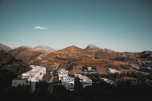 Free Aerial view of a Mediterranean village nestled among hills with a warm, earthy tone. Stock Photo