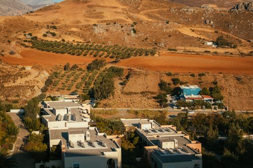 Free A bird's eye view of a village and fields in dry countryside, showcasing a sunny landscape. Stock Photo