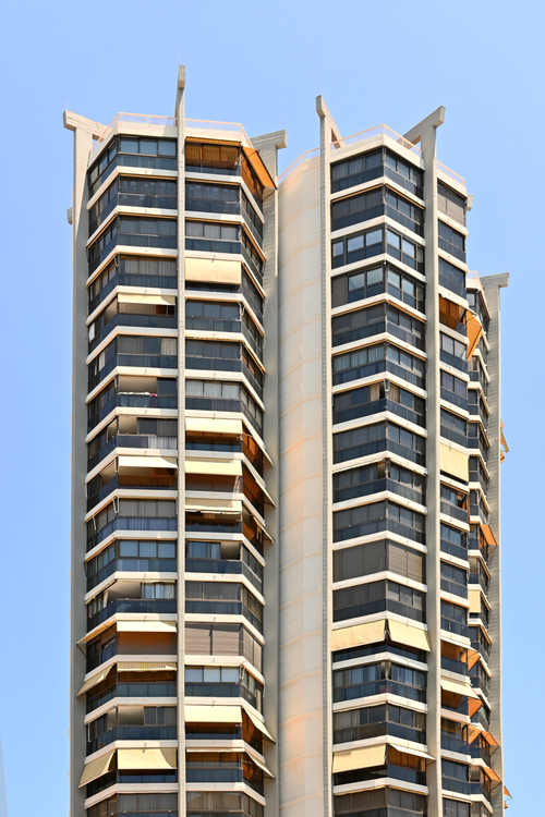 Free Contemporary skyscraper with glass facade in a sunny coastal city. Stock Photo