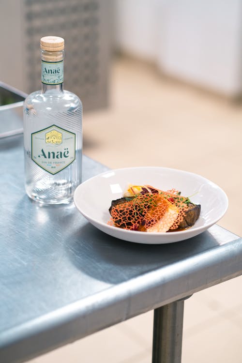 Free A Bottle of Alcohol and Plate with Food Stock Photo