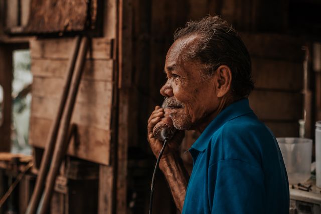 Man in his fifties reading his phone with a thoughtful smile