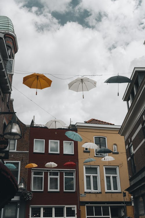 Colorful Umbrellas Hanging over the Street Between Houses