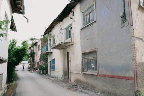 Free Abandoned urban street with cracked buildings, reflecting decay and desolation in a quiet city area. Stock Photo