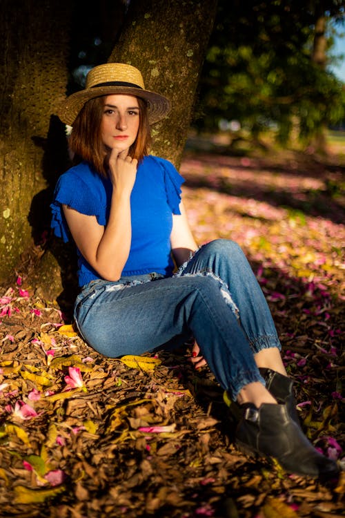 Woman in Hat Sitting by Tree