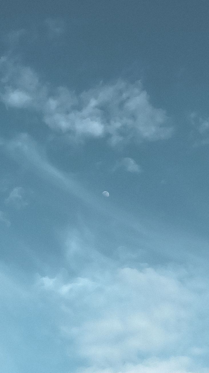 A serene view of the half moon amidst clouds in Houston, Texas.