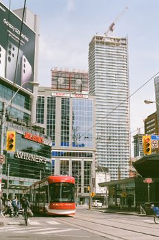 Dynamic urban scene featuring a Toronto streetcar amidst skyscrapers and city life.