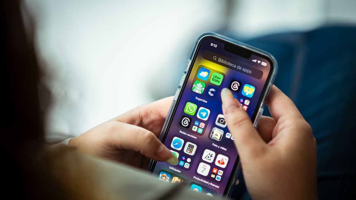 スマホの画面で複数の不動産投資会社の入居率や免許番号を照合してから面談に臨む女性のイメージ写真です。