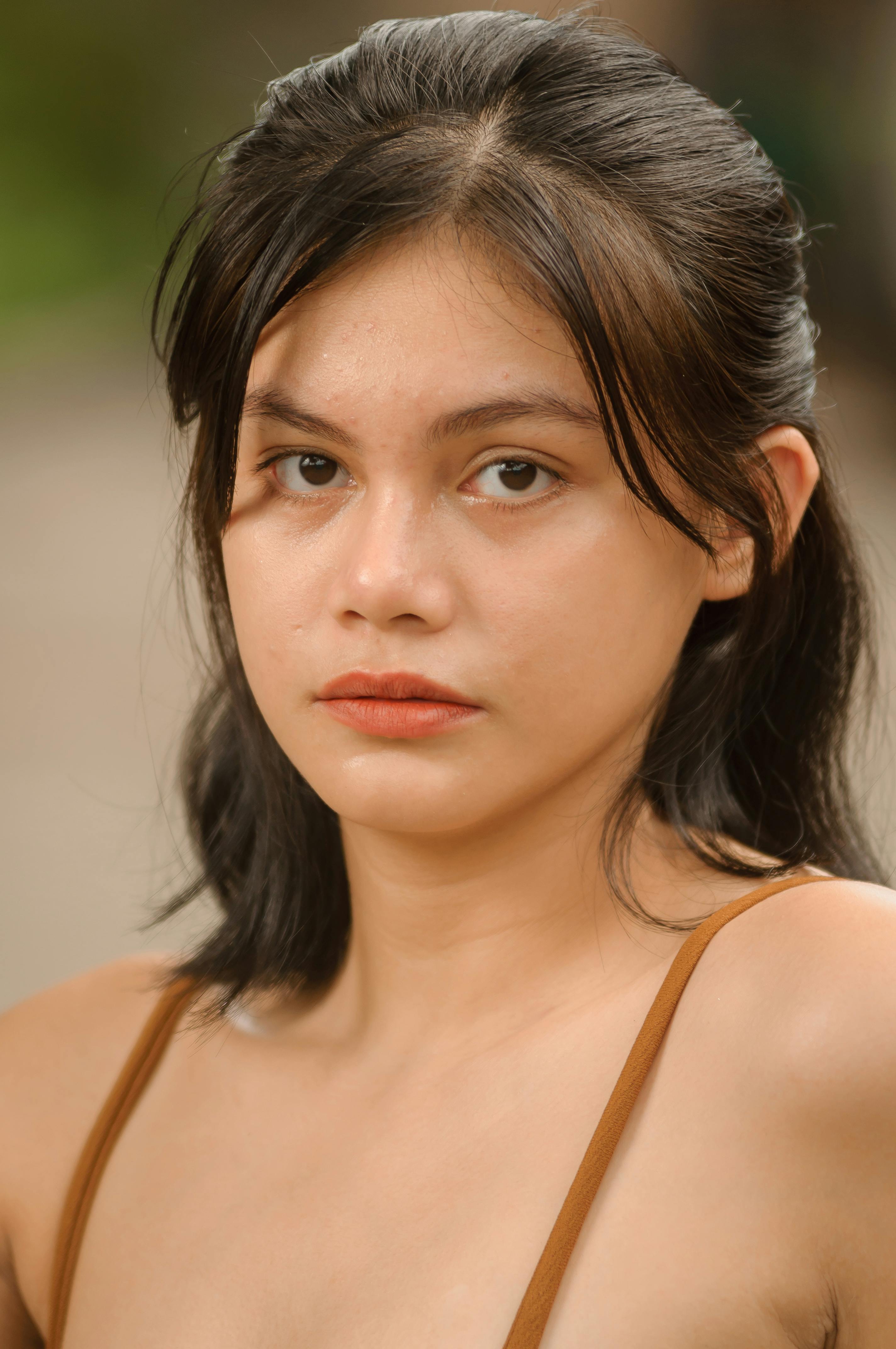 Close-up portrait of an Asian woman with natural makeup and long black hair.