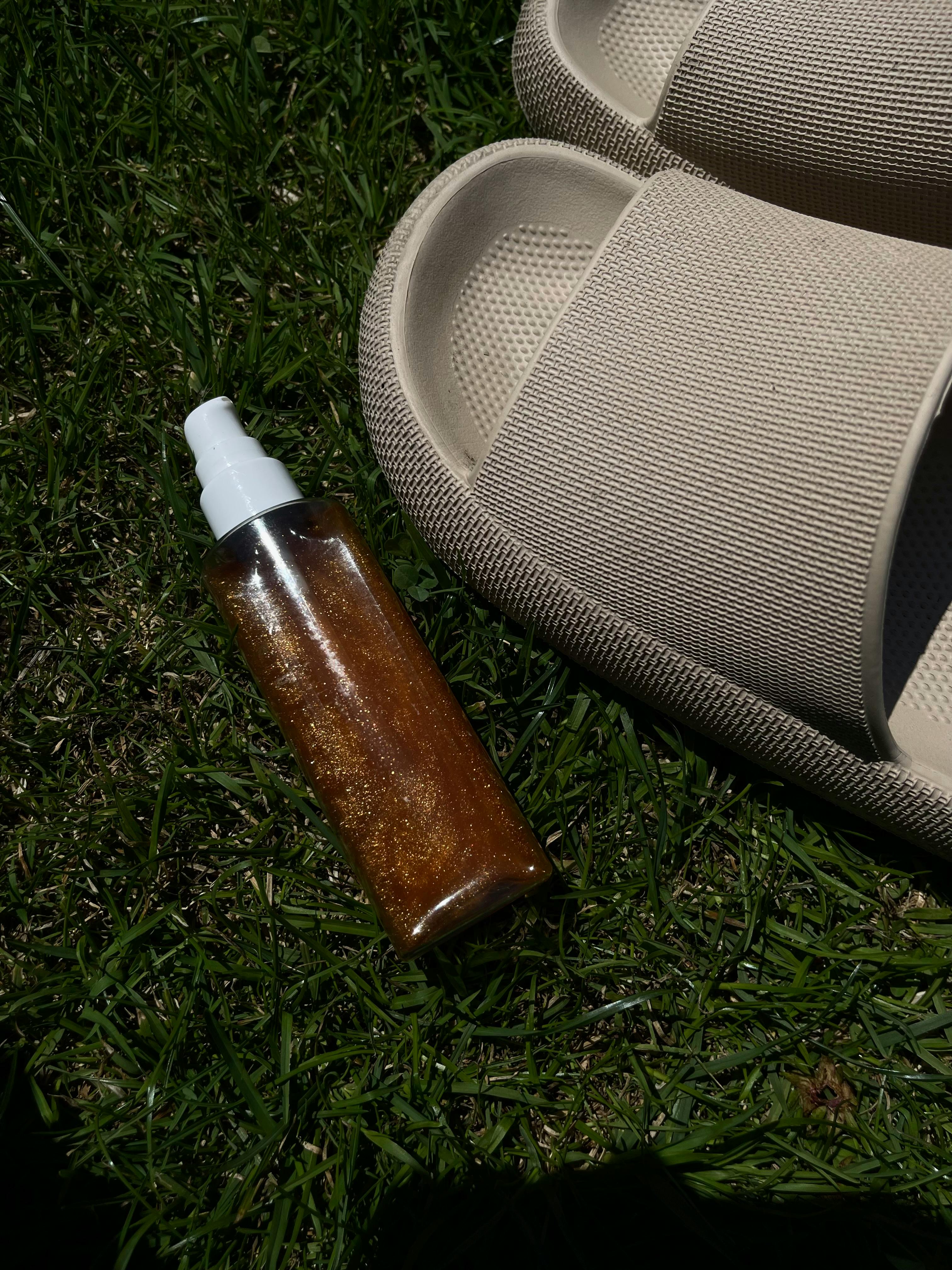 Bottle with Cosmetics and Flip Flops on Grass Free Stock Photo