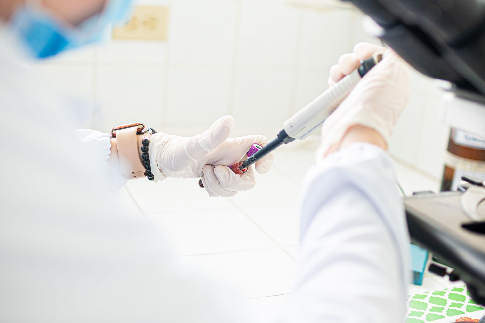 A medical professional using pipette in a lab setting, emphasizing precision and care.