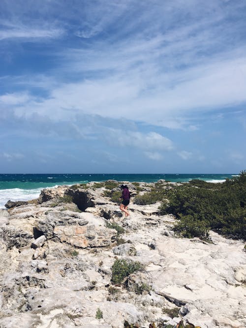 Person Stand in the Bottom of Rock Formation