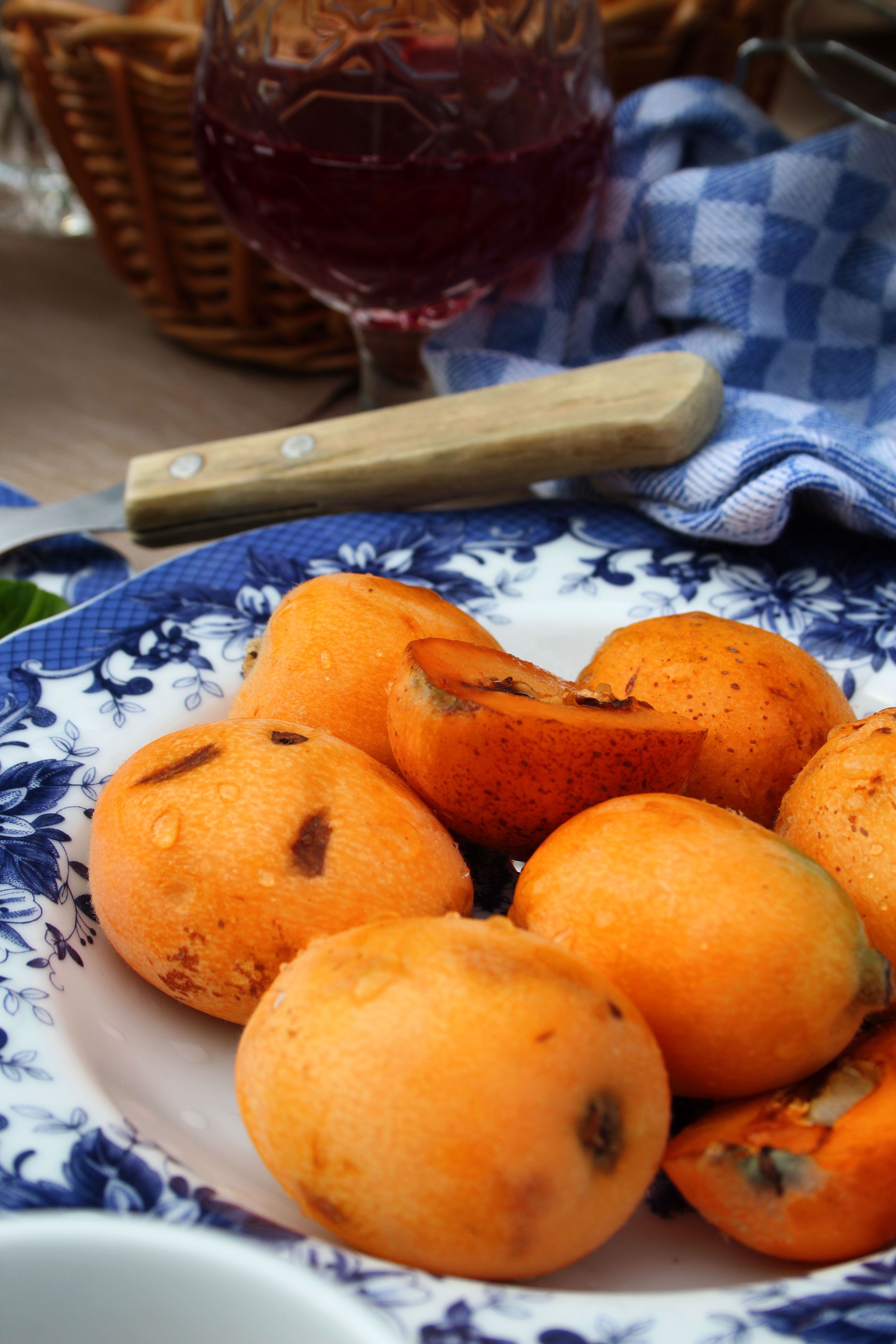Close-up of washed loquats on a blue floral plate, perfect for a refreshing seasonal snack.