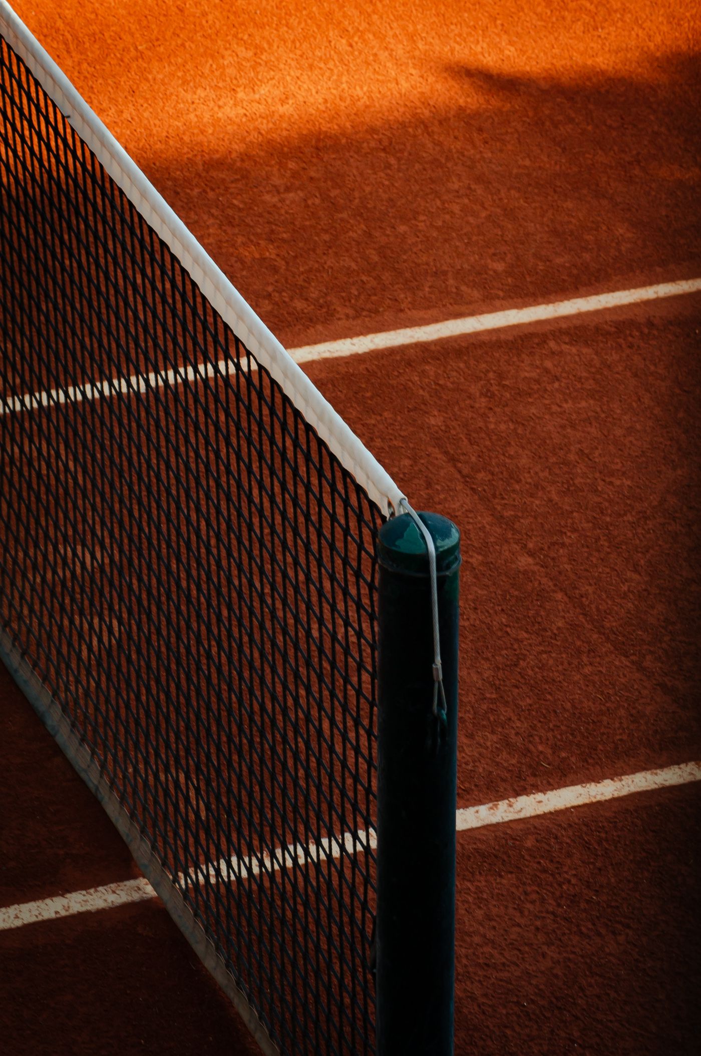 Net post and mesh over a clay court