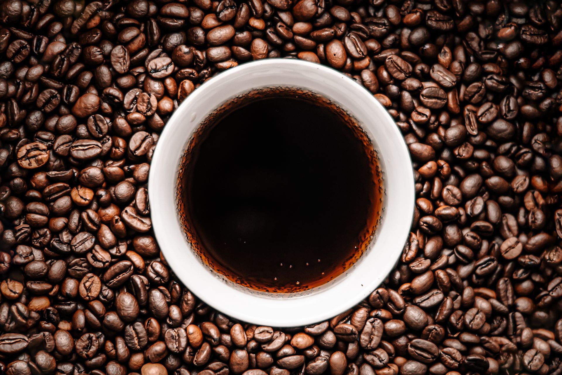 Coffee beans and a cup of coffee on a table