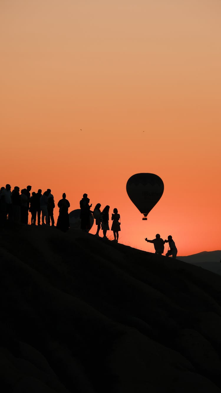 People And Hot Air Balloon Silhouette At Sunset