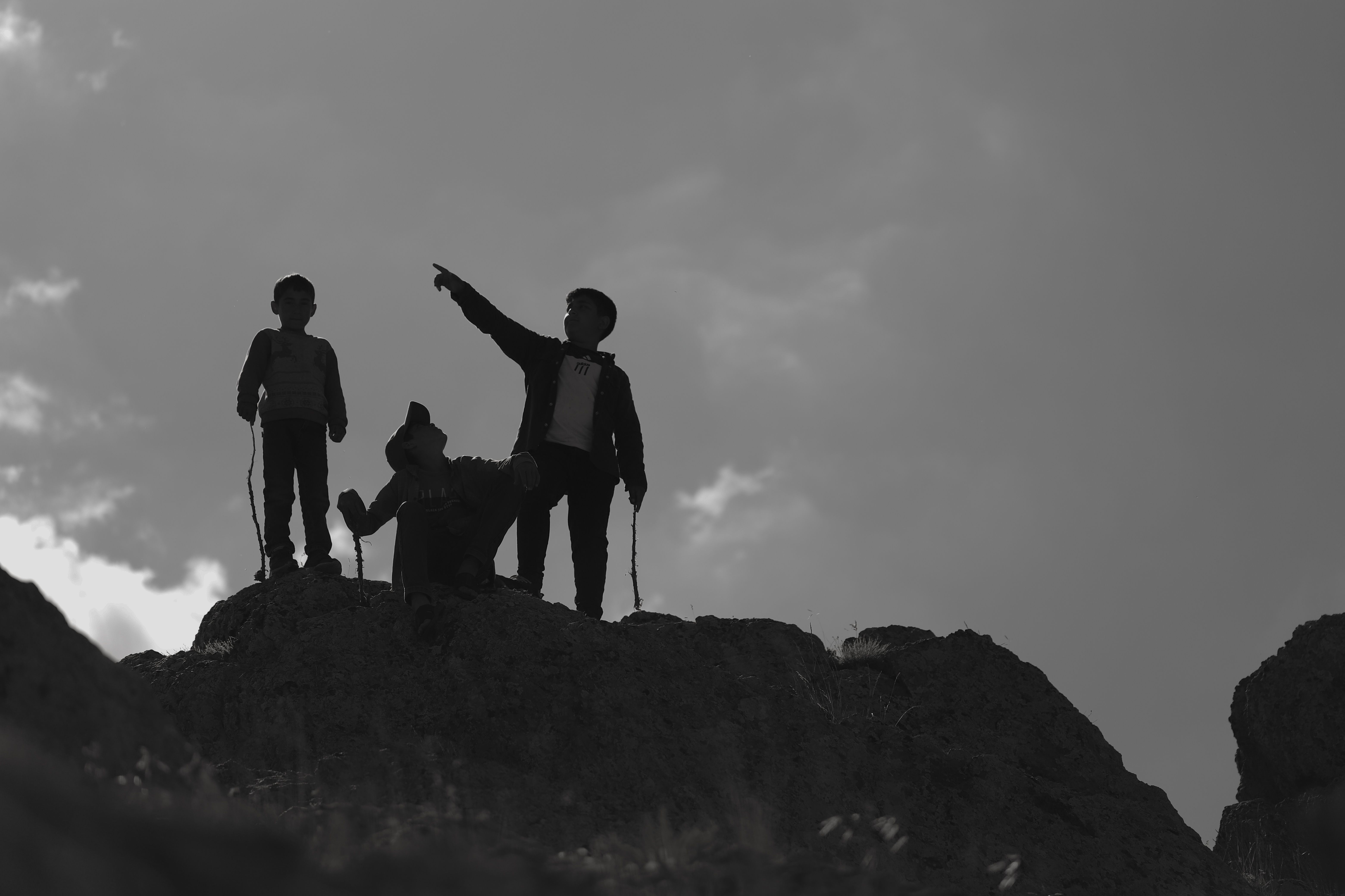 Free Children on Rock under Clouds Stock Photo