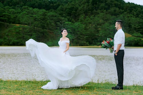 Невеста стоит перед женихом с букетом цветов