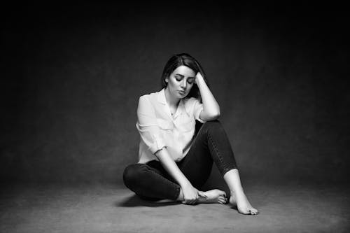 Free Young Woman Sitting on the Floor with her Eyes Closed  Stock Photo