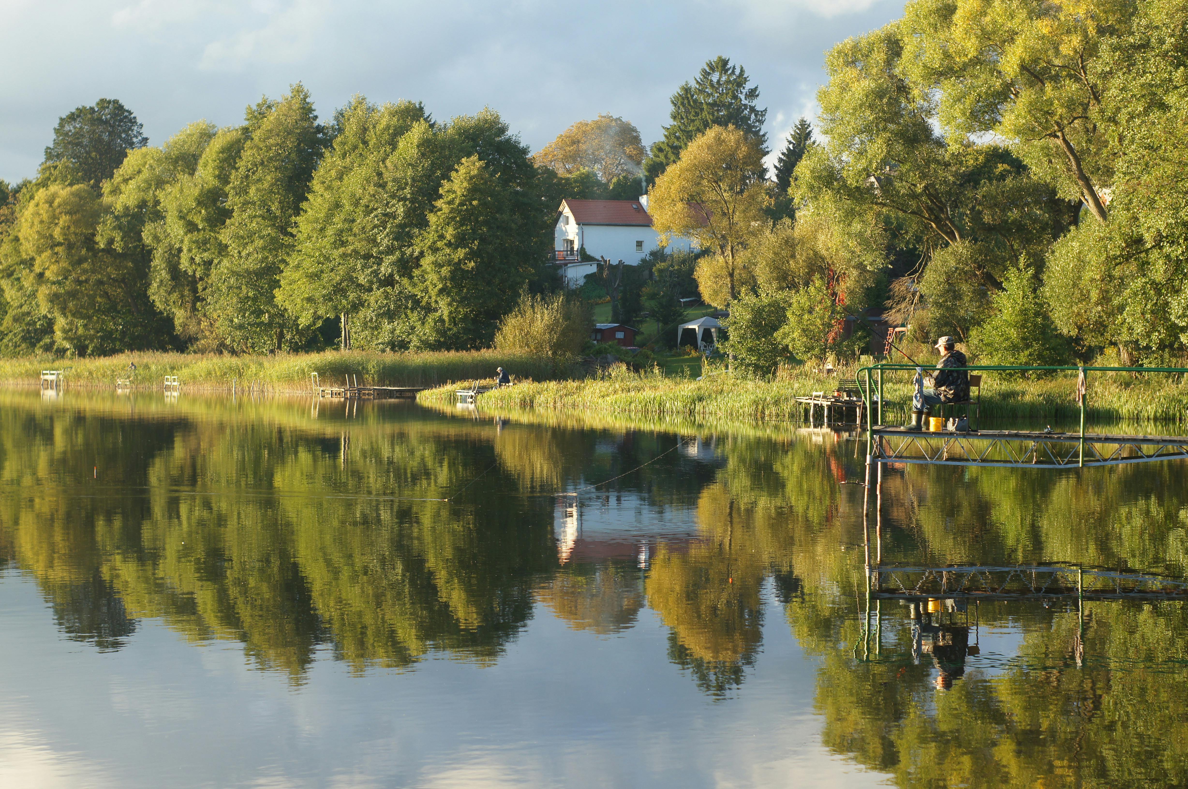 a man fishing on the water near a lake