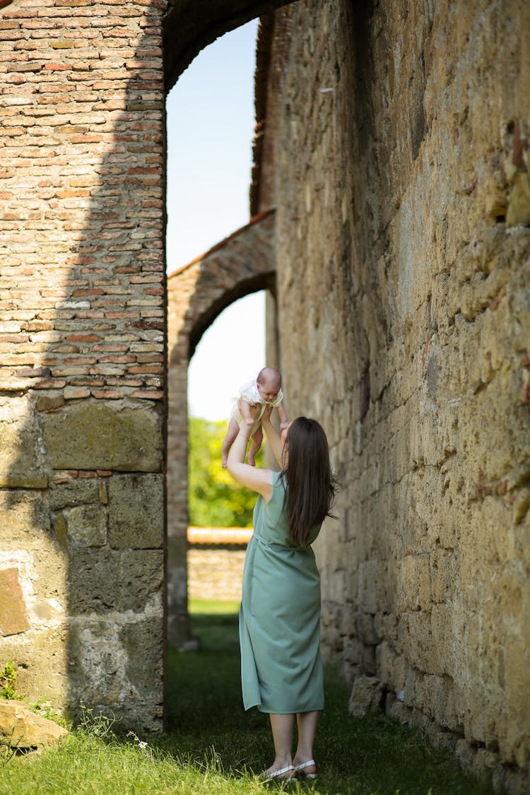 Mother Holding Baby Among Stone Walls