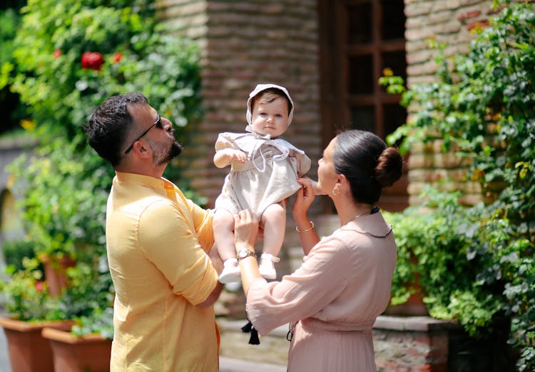 Mother And Father Holding Baby