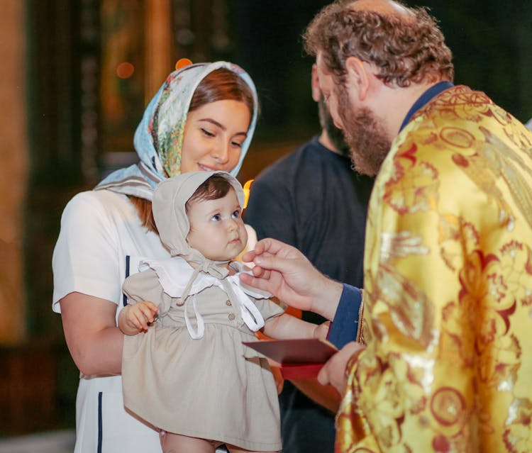 Mother And Priest With Baby On Orthodox Baptism Ceremony