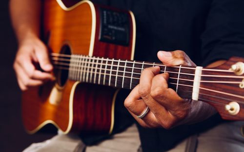 Acoustic guitar leaning against a wall in natural light