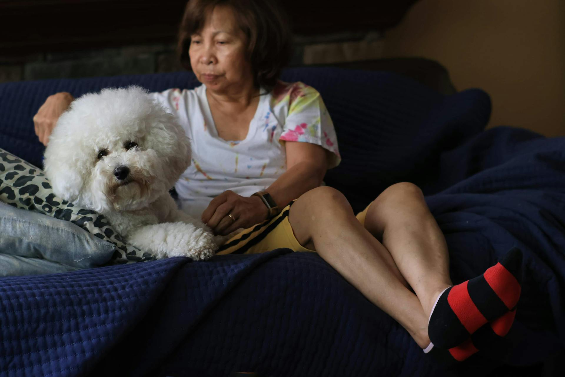 Une femme assise sur un canapé avec un caniche