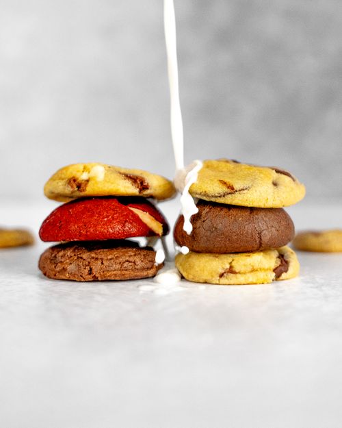 Free Delicious stack of assorted cookies with a splash of milk pouring down on a gray background. Stock Photo