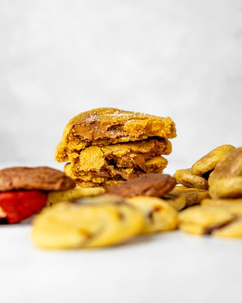 Free Delicious variety of homemade cookies stacked on a white surface, perfect for snacks and treats. Stock Photo