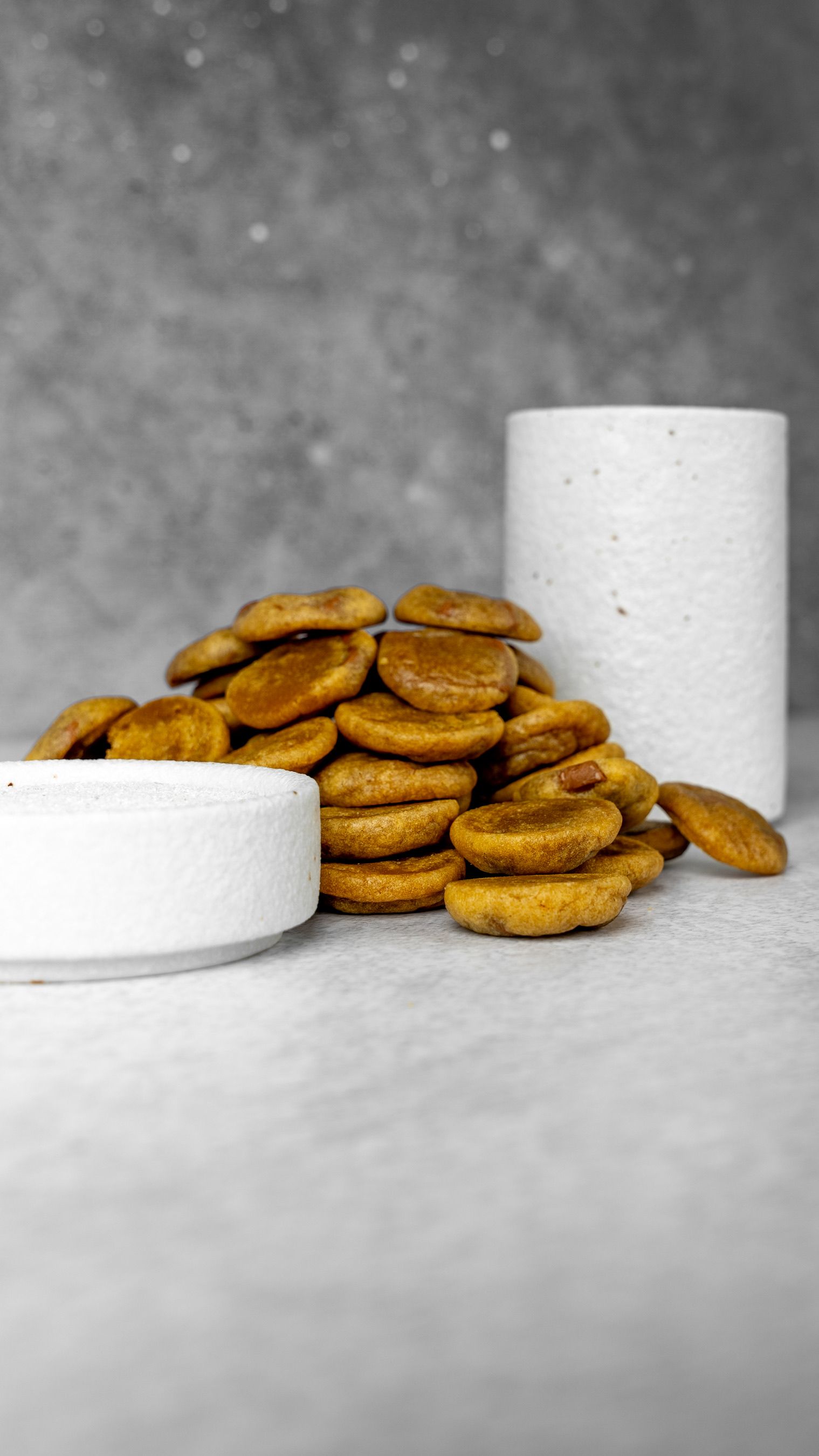 A stack of fresh baked cookies neatly arranged on a textured gray background, ideal for food photography.
