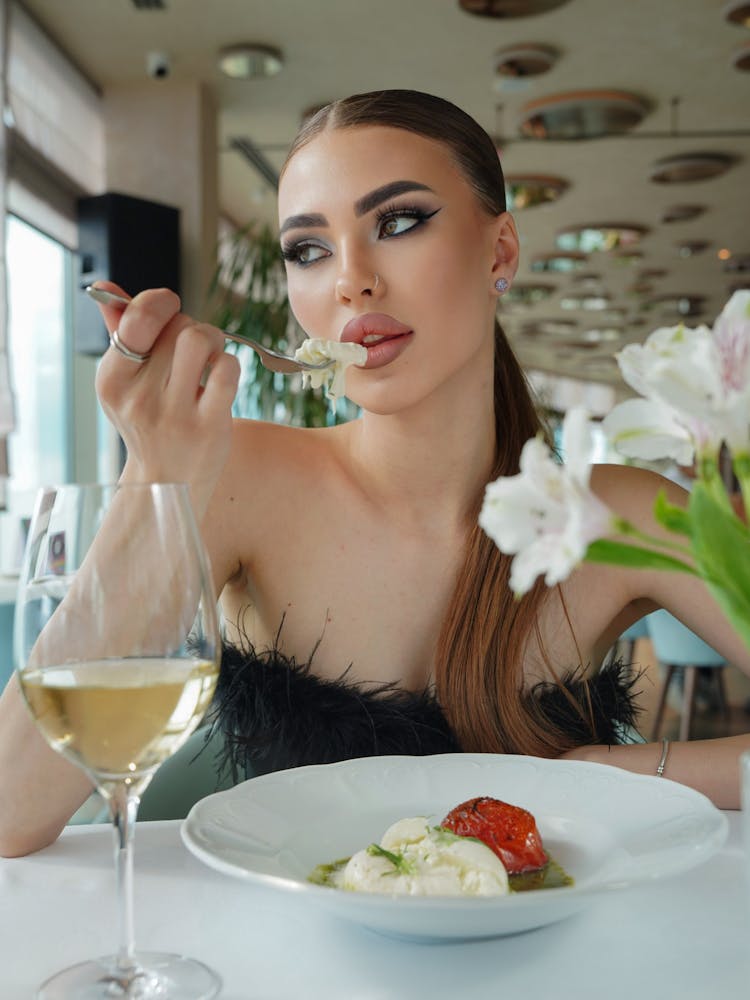 Woman Sitting And Eating In Restaurant