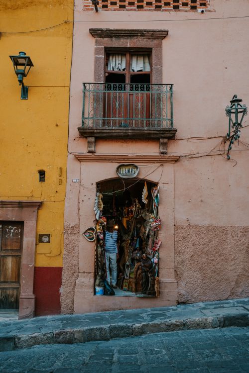 Free Rustic entrance of a traditional artisan shop with vibrant facade and balcony. Stock Photo