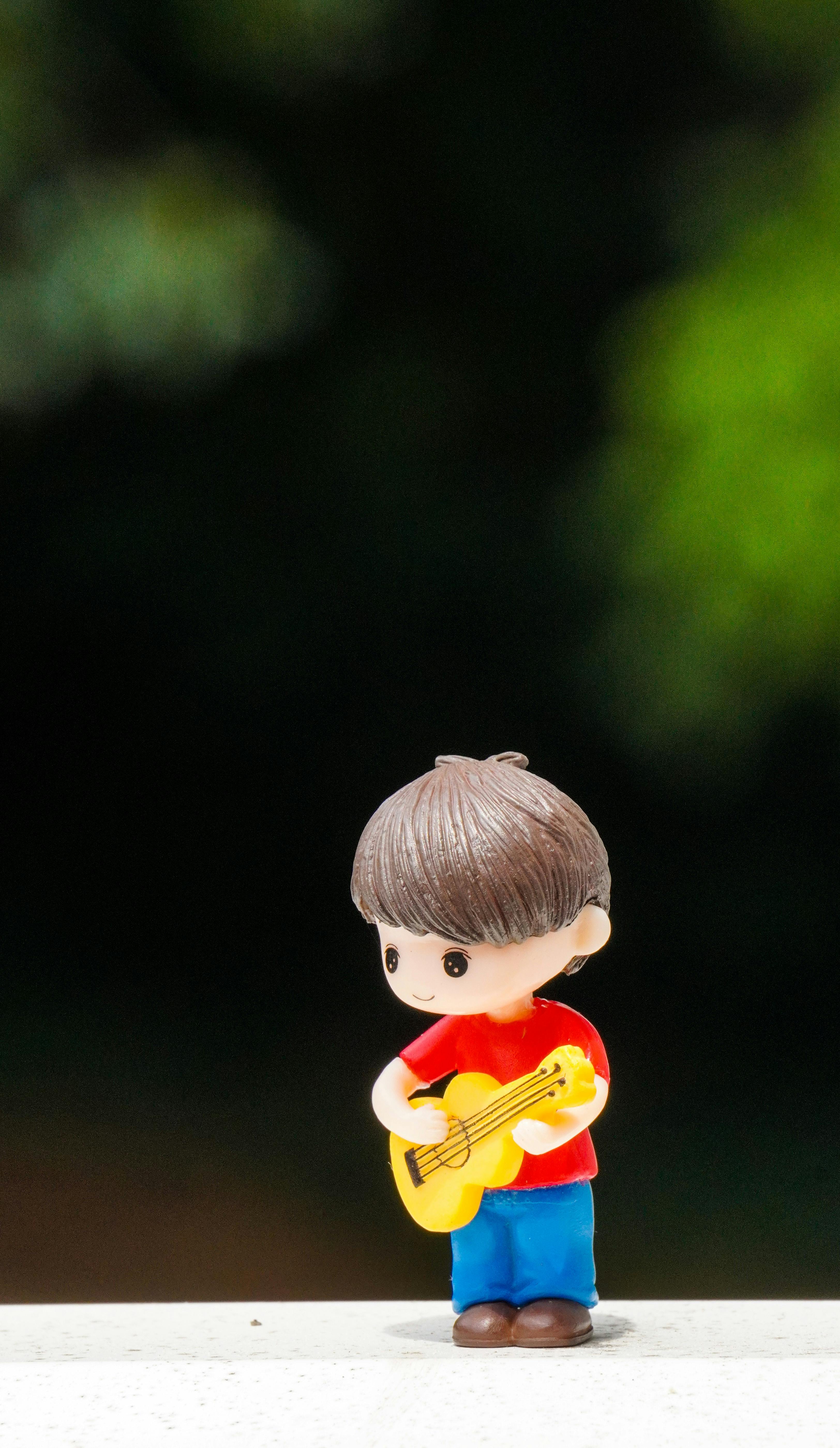 Cute figurine of a boy with a guitar, perfect for decoration and playful ambiance.