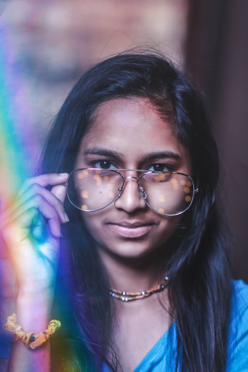 Shallow Focus Photography Of Woman Holding Her Eyeglasses