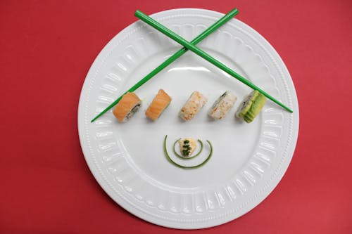 Sushi Em Placa De Cerâmica Branca Com Pauzinhos Verdes