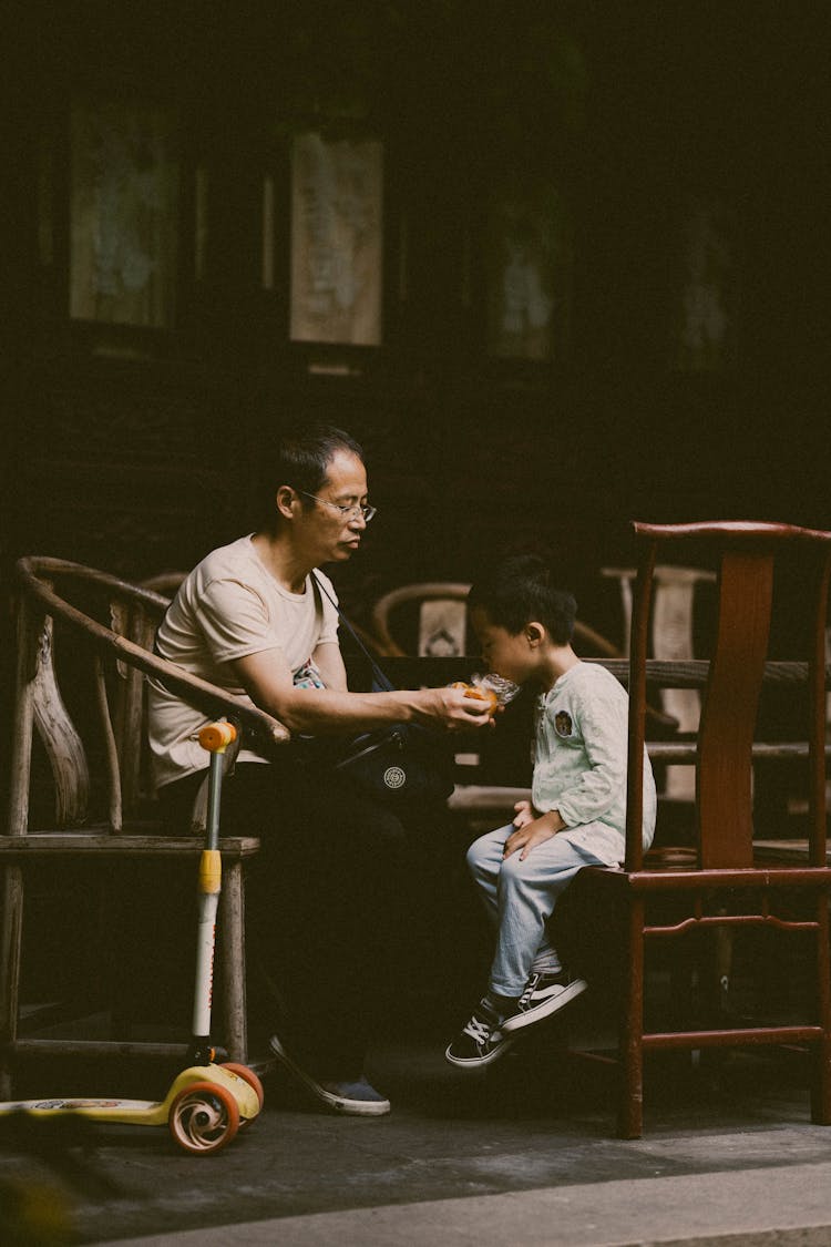 Father Sitting And Feeding Son