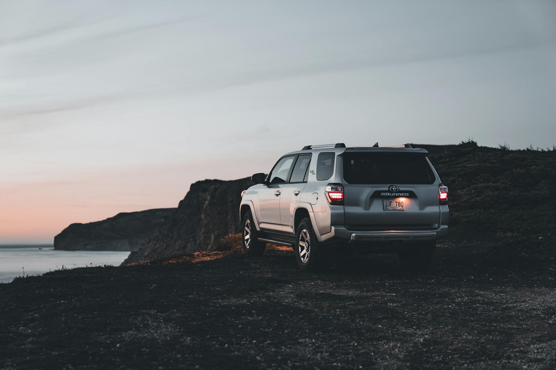 Explore the rocky coastline with a modern Toyota 4Runner SUV at sunset.