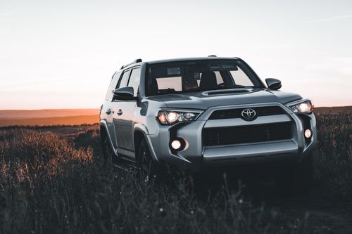 Free Silver Toyota SUV parked off-road during sunset, showcasing rugged scenery and adventure vibes. Stock Photo
