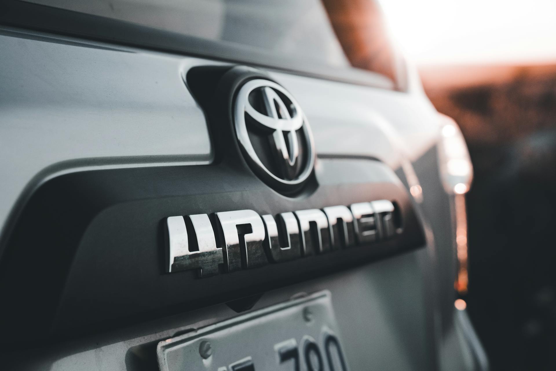 Detailed close-up of a Toyota 4Runner emblem, highlighted by the warm sunset light.