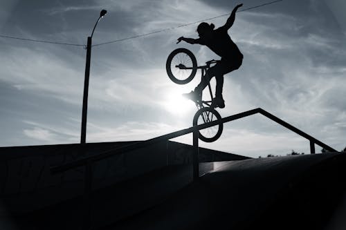 Man Doing Stunts on Bike at Sunset