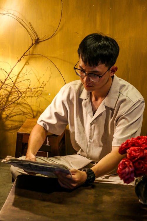 Man in Eyeglasses Sitting and Reading