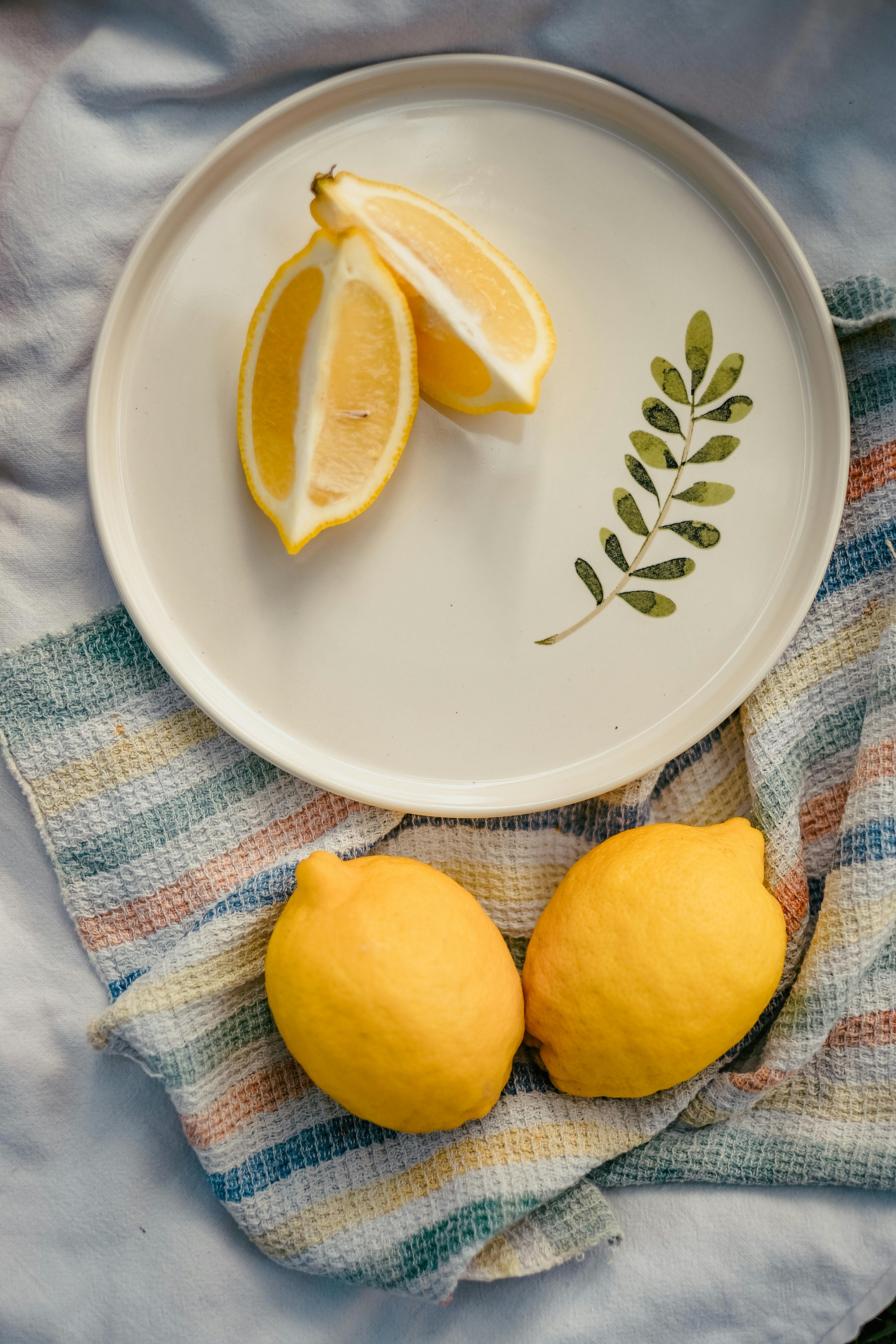 Close-up of fresh lemon slices on a decorative plate on a cloth.