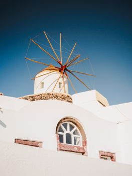 Stunning view of a traditional windmill against a clear blue sky in Santorini, Greece.