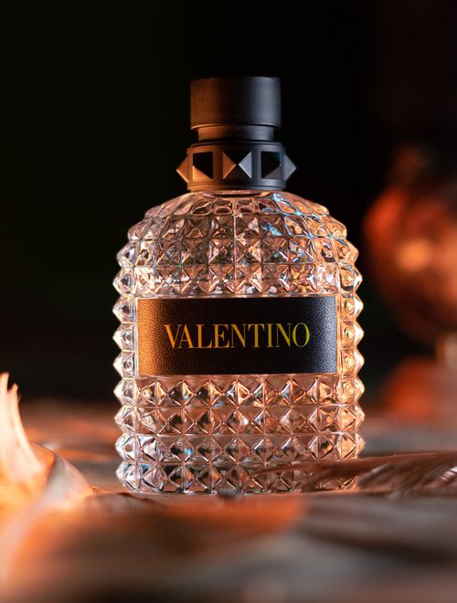 Free A luxury Valentino perfume bottle captured in warm lighting, exuding elegance. Stock Photo