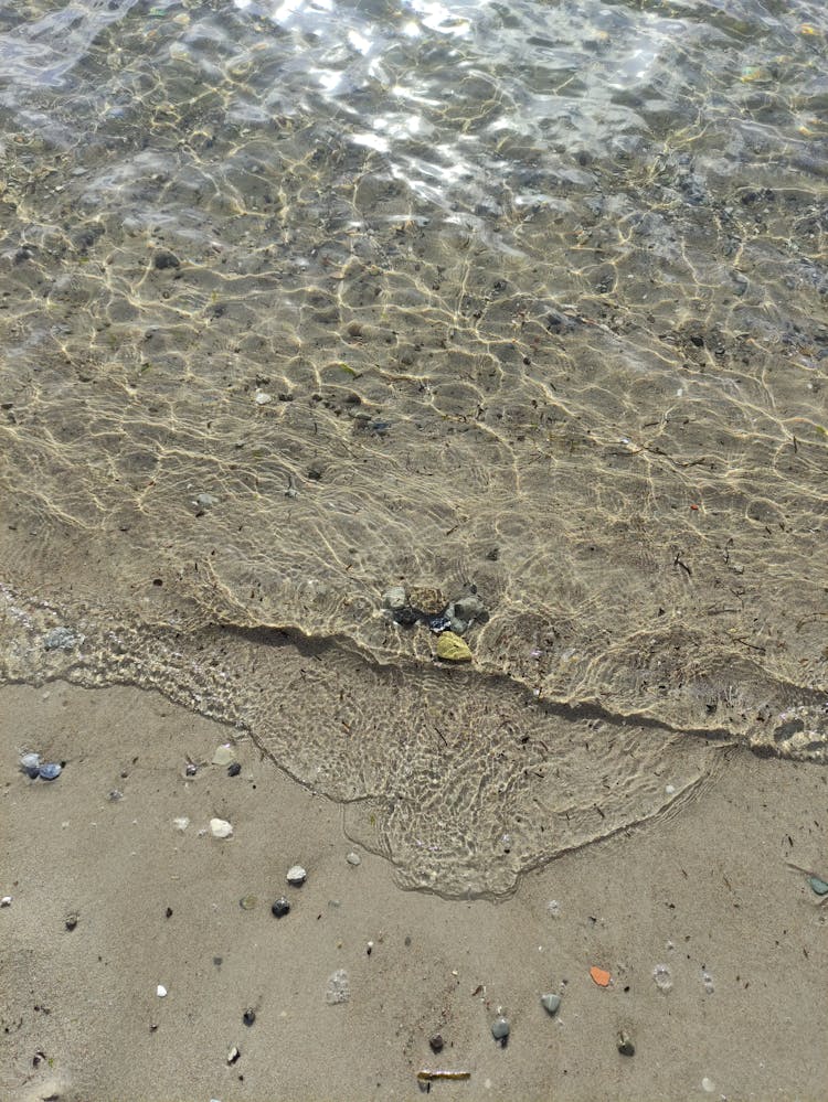 Close-up Of Water Washing Up The Beach 