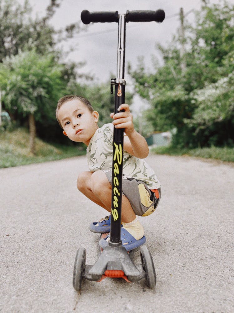 Active Little Boy On Scooter On Street